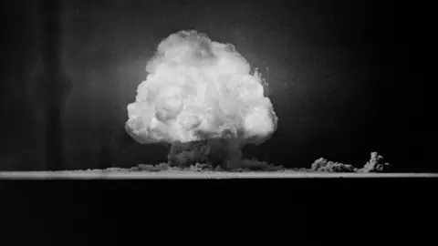 Getty Images A mushroom cloud above the New Mexico desert seen in a black and white photo from 1945