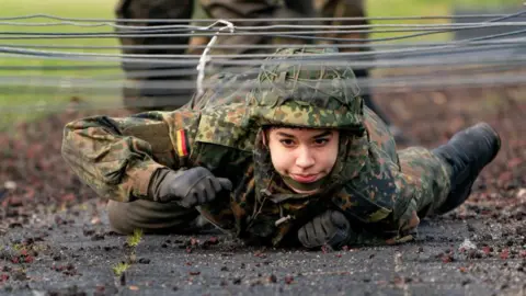 Getty Images A soldier crawls under wires during German military training, 2021