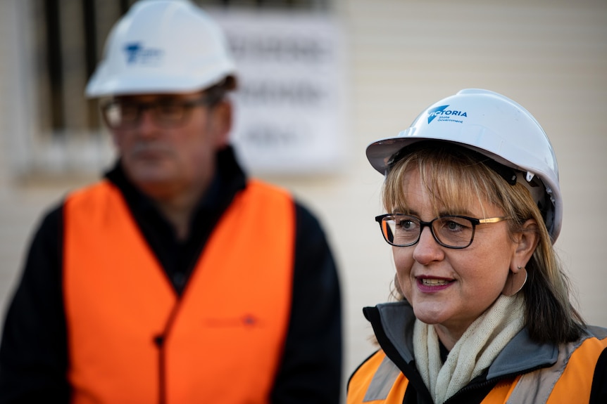 A woman and man in hard hats and high vis vests