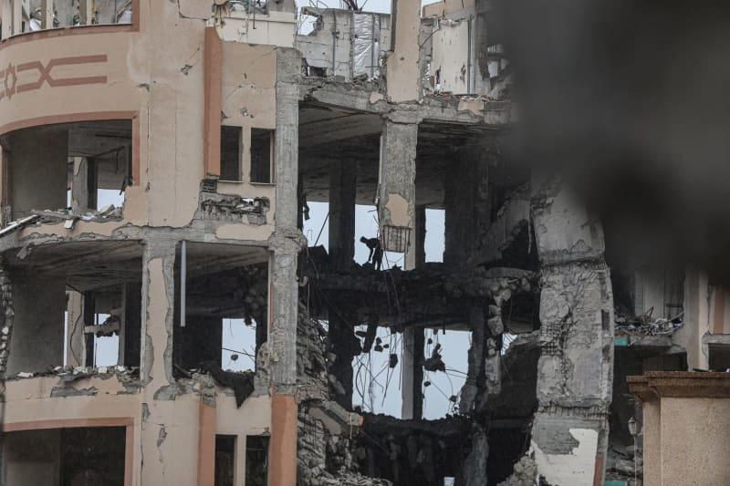 Displaced Palestinians look on from the destroyed buildings of the Islamic University in Gaza City. Omar Ashtawy/APA Images via ZUMA Press Wire/dpa