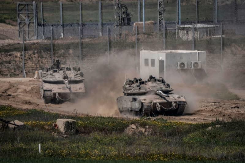 Israeli tanks are seen on the border between Israel and Gaza. Israel launched a series of air strikes against the Palestinian Islamist group Hamas in the Gaza Strip on Tuesday after efforts to extend the ceasefire failed. Ilia Yefimovich/dpa