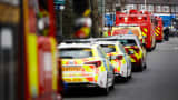 Police vehicles and fire engines are seen near the scene where a fire broke out at a substation supplying power to Heathrow Airport in Hayes, west London on March 21, 2025.