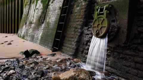 An overflow pipe releases water into the river Thames