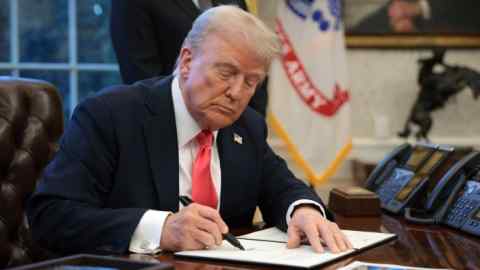 President Donald Trump signs an executive order in the Oval Office